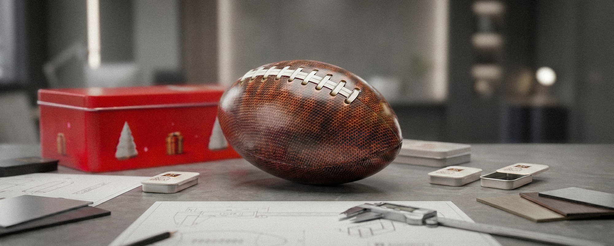 Dekorative Dose in Form eines braunen American Footballs neben einer roten Weihnachtsdose auf grauer Oberfläche; festliche Produktaufnahme mit kleinen Metalldosen.