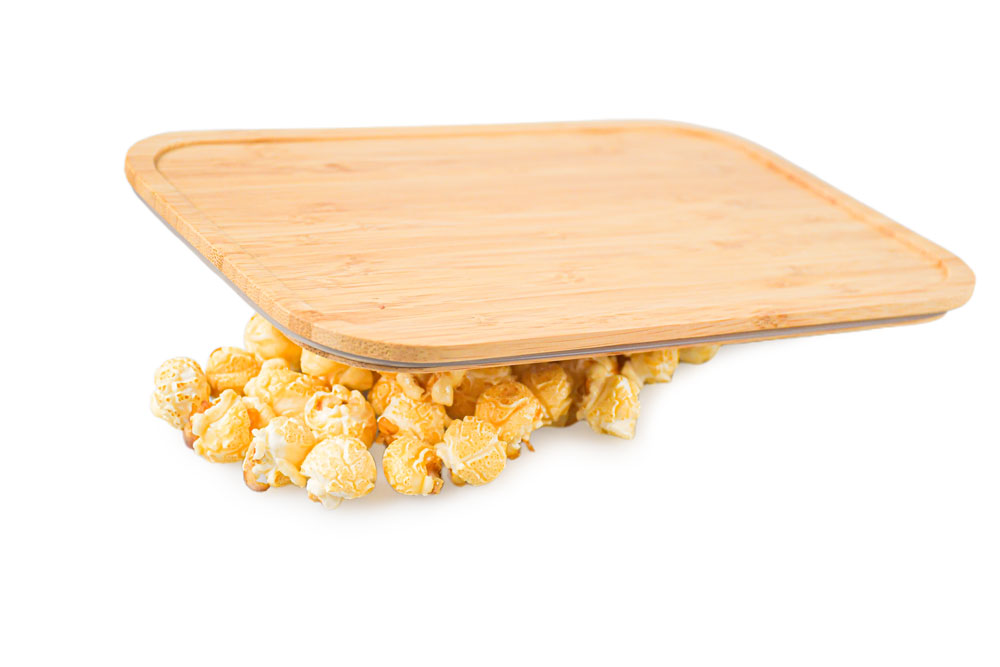 Bamboo lid on white background with popcorn – decorative replacement lid for lunch box