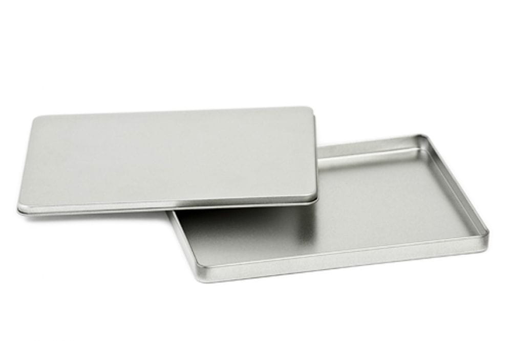 Geöffnete DIN-A6-Weißblechdose aus silberfarbenem Blech mit abgenommenem Deckel, auf weißem Hintergrund dargestellt.
