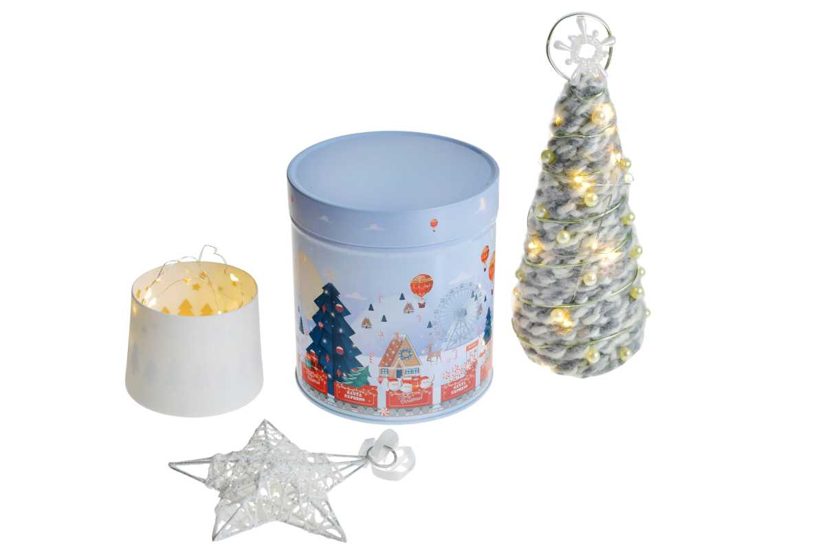 Geschlossene runde Blechdose mit winterlichem Weihnachtsmotiv in hellblau, abgebildet neben dekorativen Weihnachtsaccessoires, auf weißem Hintergrund.