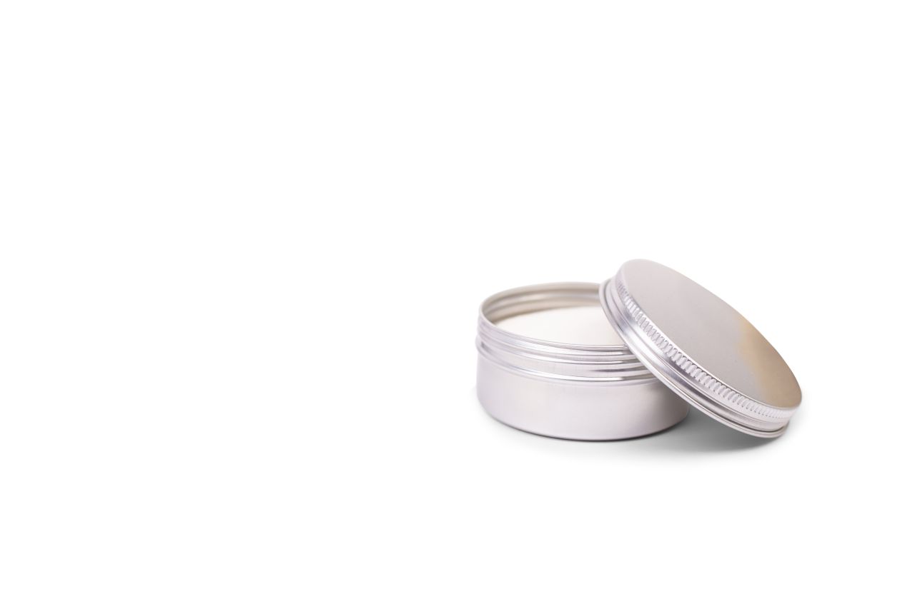 Geöffnete silberne Aluminium-Kosmetikdose mit 130 ml Volumen, gefüllt mit weißer Creme, auf weißem Hintergrund fotografiert. Der Deckel liegt locker auf der Dose.
