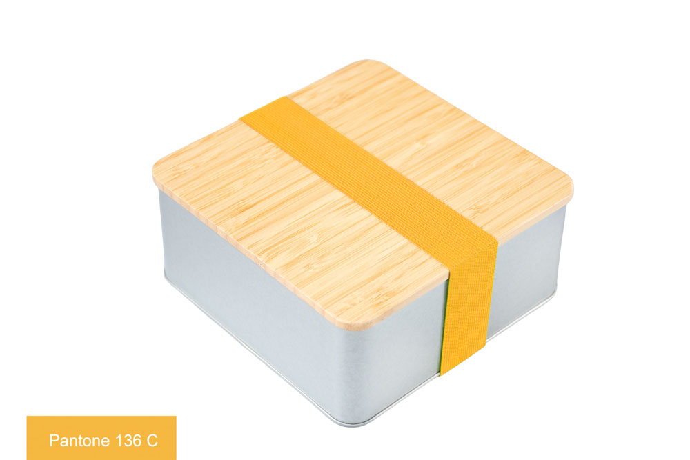 Square tin made of silver-colored metal with bamboo lid, decorated with yellow ribbon (Pantone 136 C), photographed on a white background.