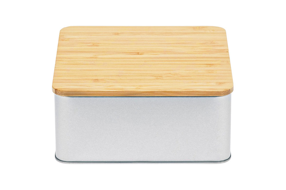 Closed square cookie tin made of silver-colored metal with flat bamboo lid, photographed against a white background.