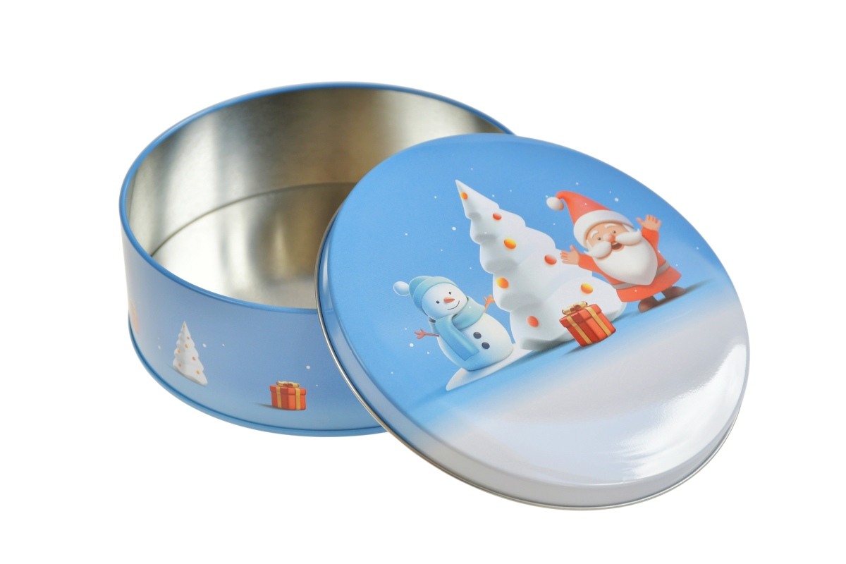Geöffnete runde Metalldose mit winterlichem Motivdeckel, zeigt Weihnachtsmann, Schneemann und Weihnachtsbaum, liegend auf weißem Hintergrund.