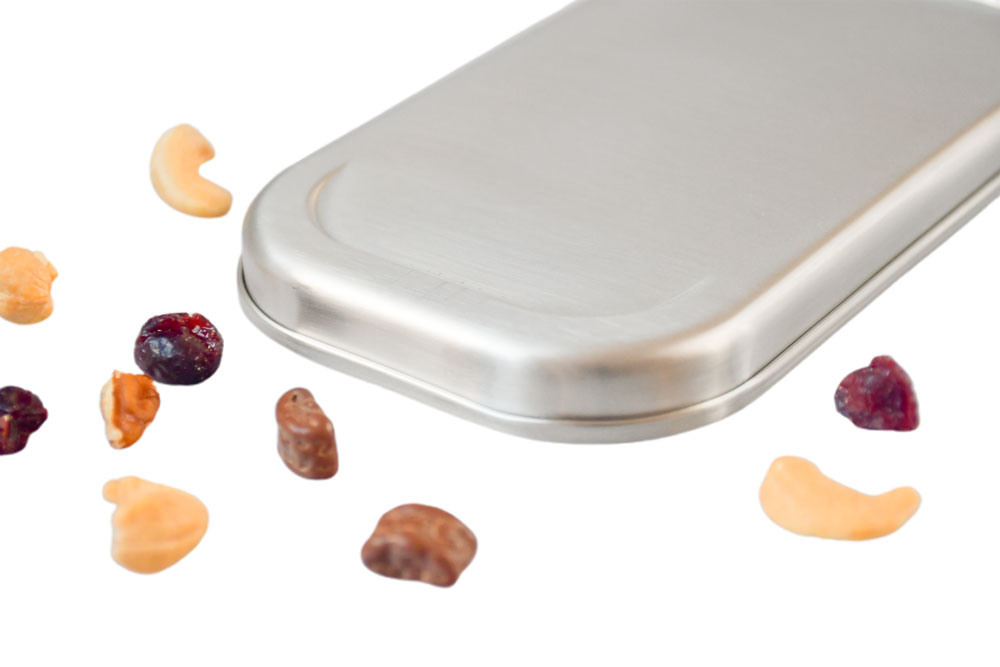 Close-up of stainless steel lid on white background with cashews and dried berries – high-quality replacement lid for lunch box