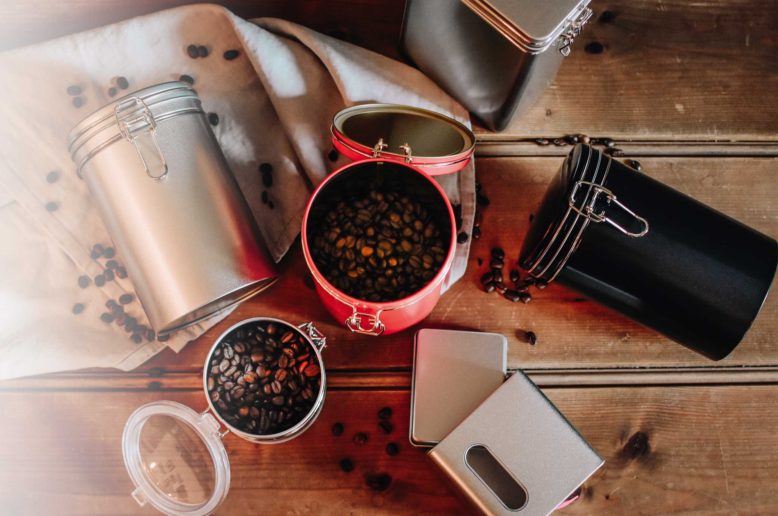 Produktbeispiele von eckigen und runden Kaffeedosen mit Bügelverschluss in verschiedenen Farben/Lackierungen